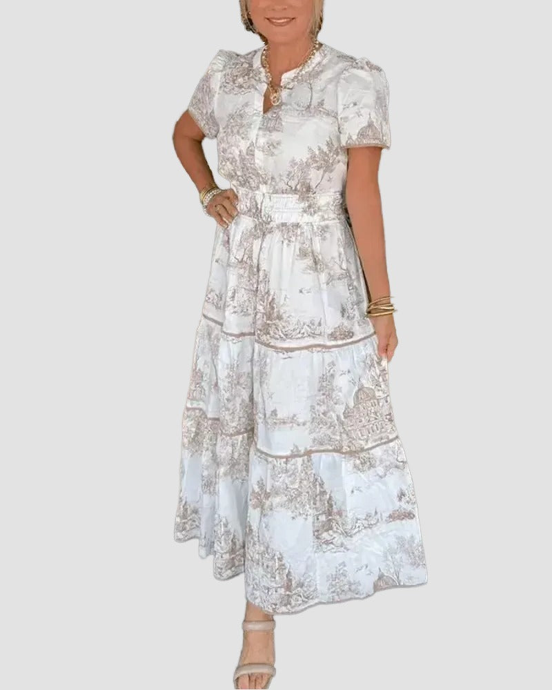 A woman wearing a white dress with a floral print, posing for a photograph.